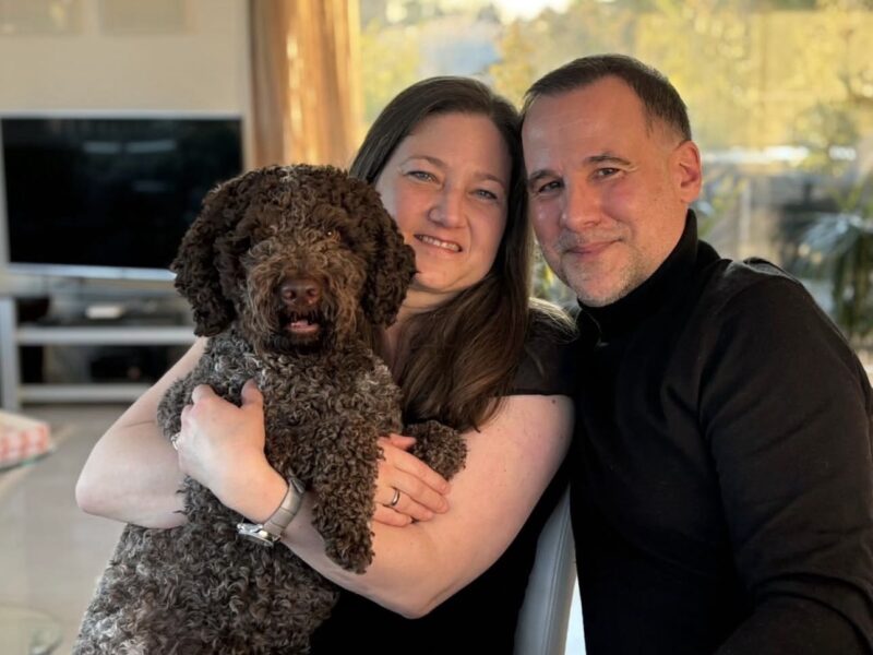 Family relaxing at home with their medium-sized brown Lagotto Romagnolo.