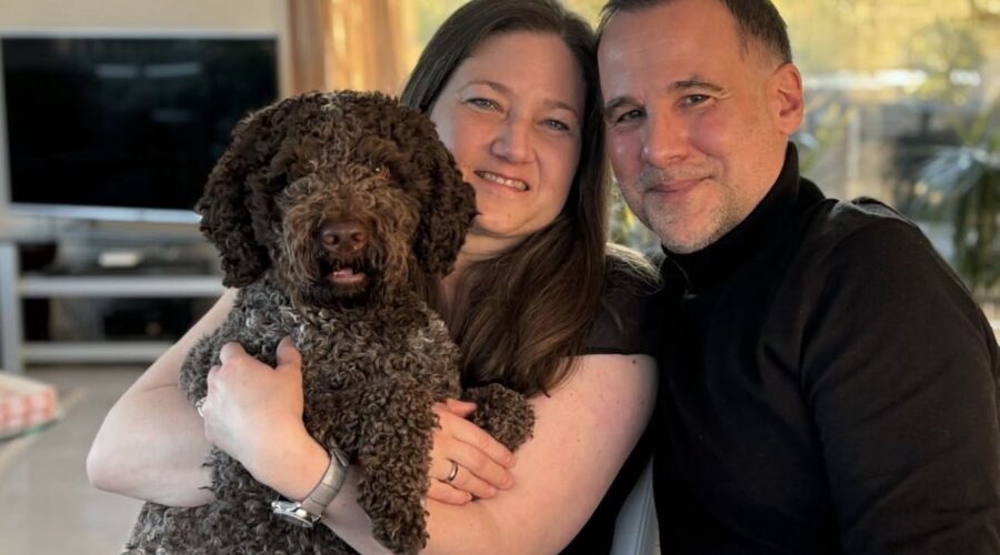 Family relaxing at home with their medium-sized brown Lagotto Romagnolo.
