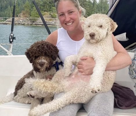 Woman and her two Lagotto Romagnolo dogs enjoying a boat trip on the lake.